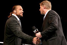 WWE COO Triple H shakes the hand of Interim Raw GM John Laurinaitis.